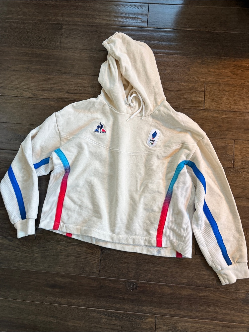 Le Coq Sportif Paris Olympics Cream Hoodie with Blue and Red Accent Stripes